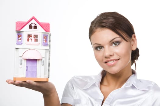Portrait of young woman holding toy house on a white background