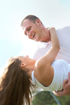 Happy male holding his girlfriend and both laughing
