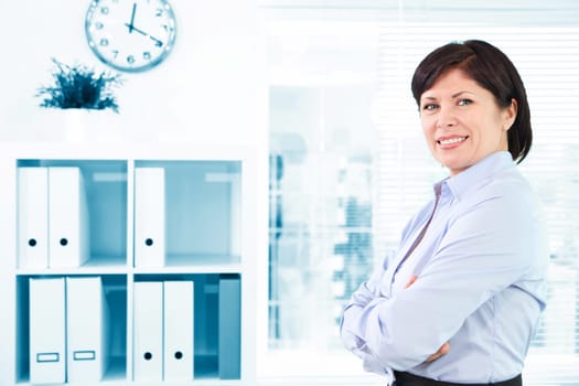 Mature businesswoman looking at camera in office