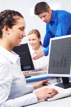 Image of secretary typing document on the background of working people