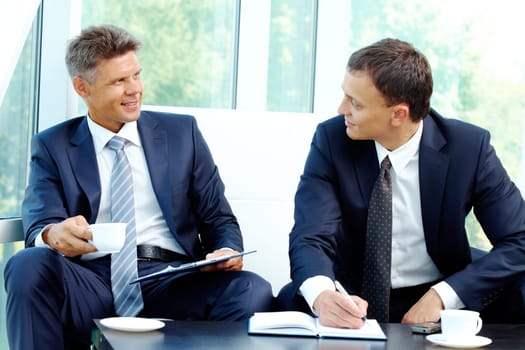 Image of smart businessmen discussing new strategy at meeting