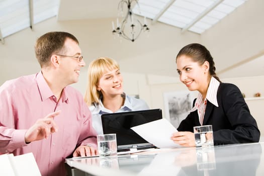 Portrait of three partners discussing a new business-plan in the conference hall