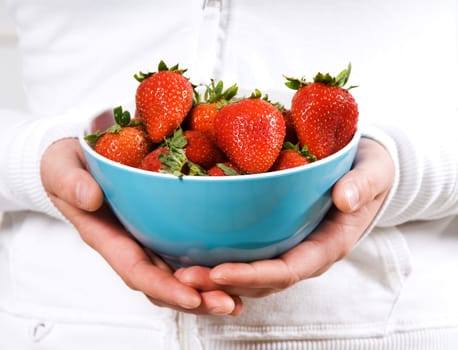 Blue bowl of strawberries fruit in red