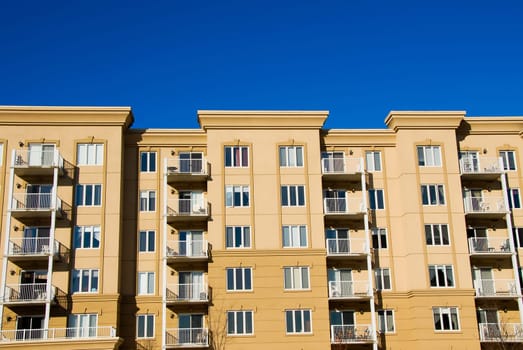 modern beige and brown apartment condos on blue sky