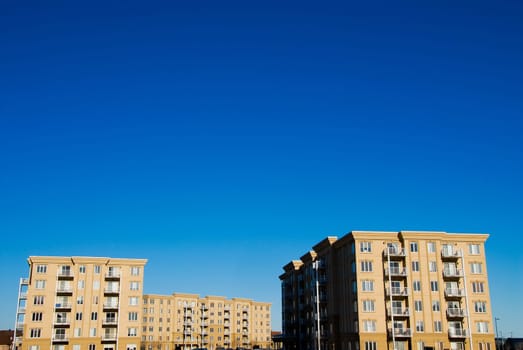 modern beige and brown apartment condos on blue sky