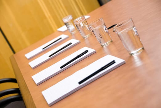 set boardroom with some water glasses and some paper