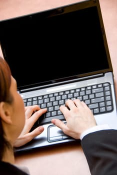 woman in a meeting typing on her laptop