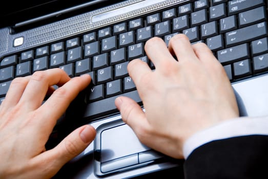 woman in a meeting typing on her laptop