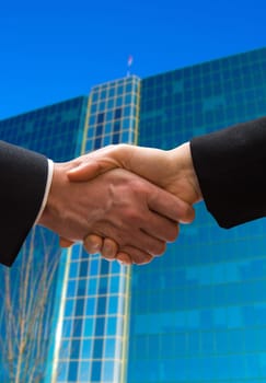 hand shake outside in front of a business building