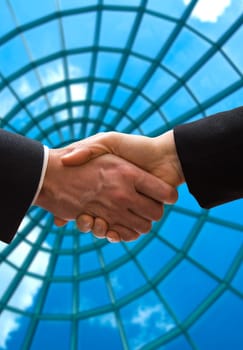 business handshake in front of some windows