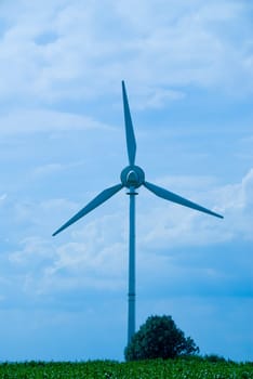 clean energy white wind turbine in corn field