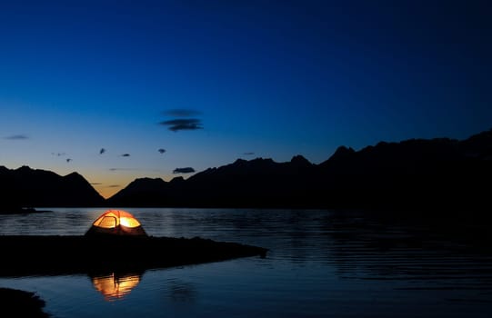 Evening lit tent in camping by nature