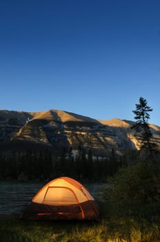 Evening lit tent in camping by nature