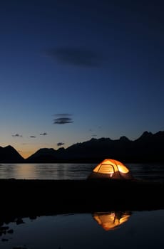Evening lit tent in camping by nature
