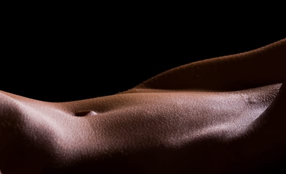 Female Tummy in the nude on black background