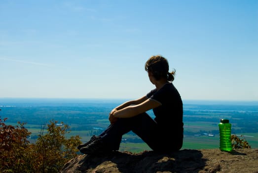 sitting woman on top of a mountain