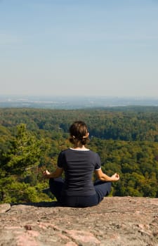 Woman on the top of a mountain meditating