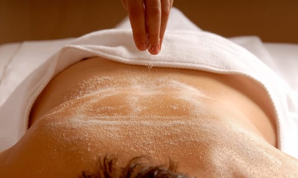 therapist dropping epsom salt on client body