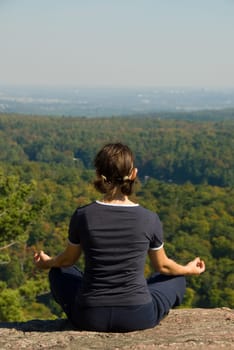 Woman on the top of a mountain meditating