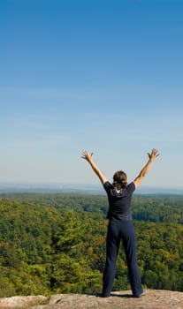 Woman on the top of a mountain happy