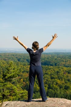 Woman on the top of a mountain happy