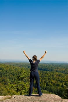 Woman on the top of a mountain happy