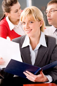 Portrait of pretty woman sitting at the table on the background of people