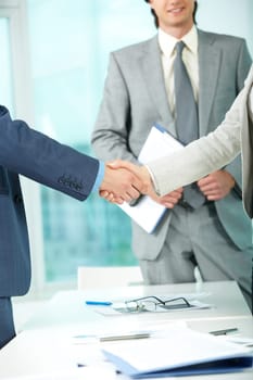 Photo of handshake of business partners after striking deal on background of elegant man