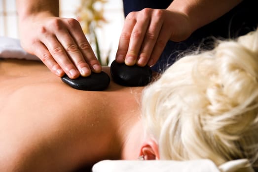 woman getting a hot stone massage at a day spa