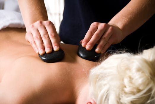 woman getting a hot stone massage at a day spa