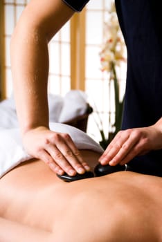woman getting a hot stone massage at a day spa
