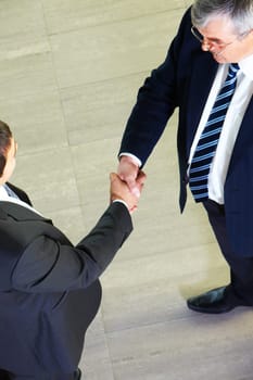 Above view of two managers shaking hands