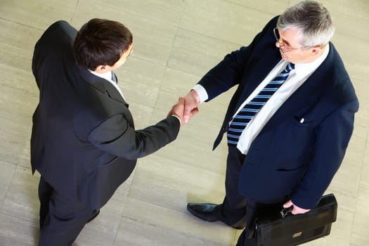 High angle view of two businessmen shaking hands