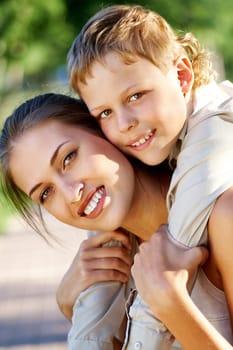 Happy mother holding her cute son and both looking at camera