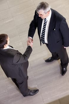 Above view of two managers shaking hands