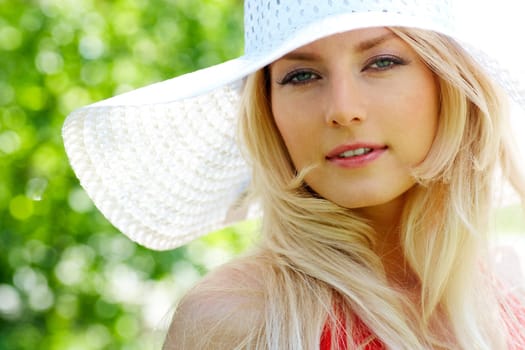 Portrait of pretty young lady in elegant hat looking at camera