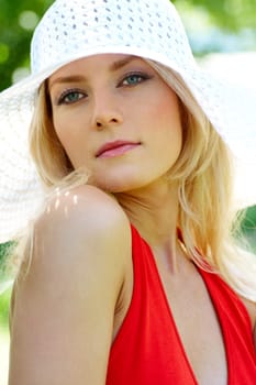 Vertical image of pretty young lady in elegant hat looking aside