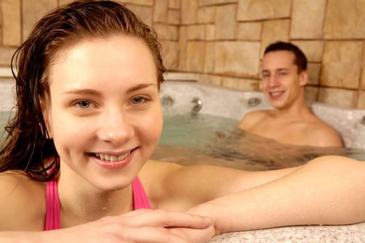 Portrait of happy girl with her boyfriend on background in swimming pool