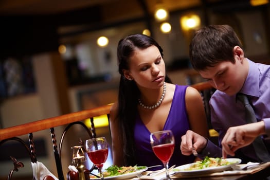 Portrait of hungry woman looking at mans food in cafe