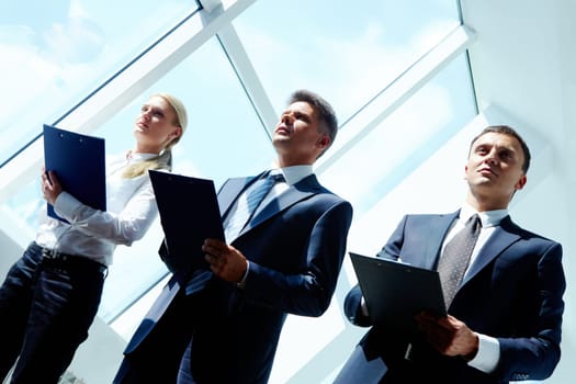 Row of three smart employees listening to report at conference