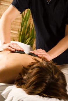 woman in a day spa getting a hot stone massage