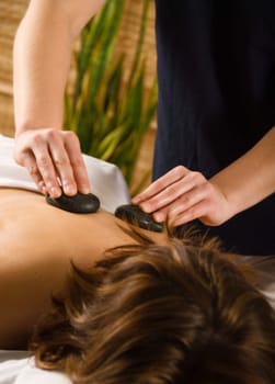 woman in a day spa getting a hot stone massage