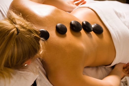 blond woman at a day spa with hot stones