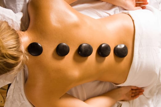 blond woman at a day spa with hot stones