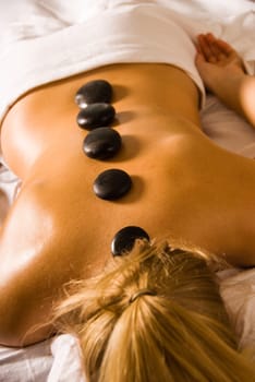 blond woman at a day spa with hot stones