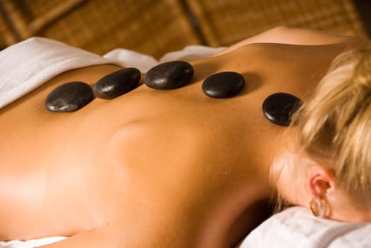 blond woman at a day spa with hot stones