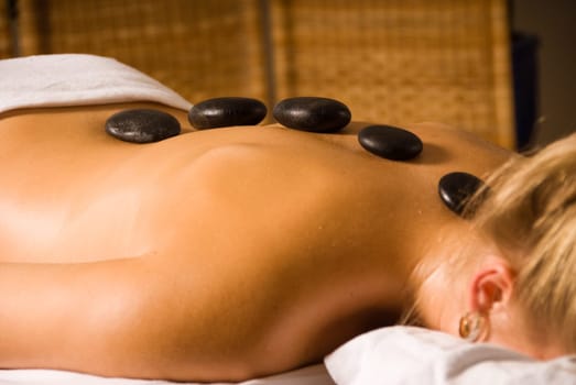 blond woman at a day spa with hot stones