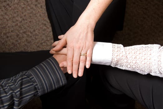 3 people clasping hands in a deal done