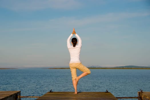 Yoga Woman on a dock by the ocean