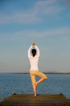 Yoga Woman on a dock by the ocean